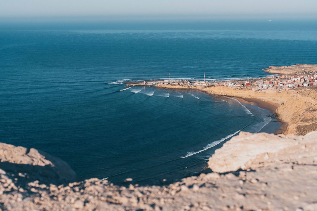 A high angle shot of the coastline of Imsouane, Morocco against a blue sea.